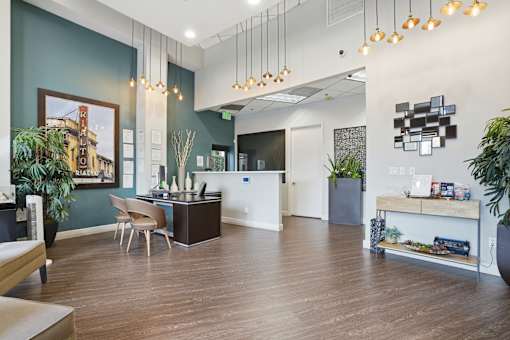A modern office space with a reception desk and a kitchenette.