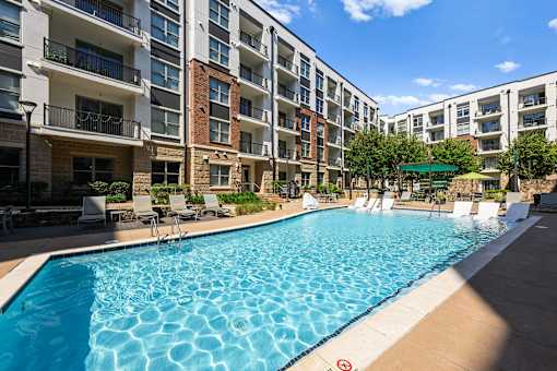 A swimming pool in front of apartment buildings.