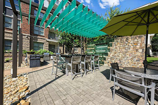 A patio with a table and chairs under a green awning.