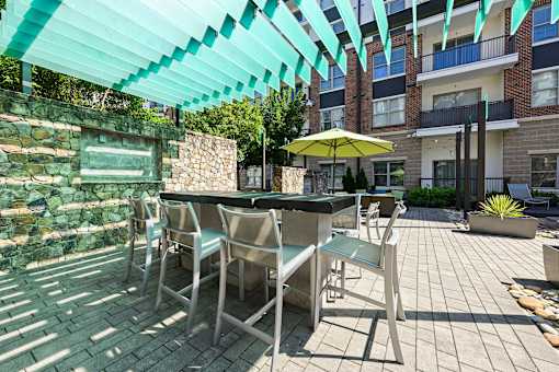 A patio with a table and chairs under a green awning.