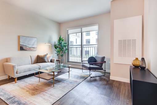 a living room with a couch and a chair and a window