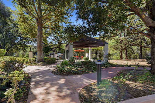 A walkway leads to a pavilion in a park.