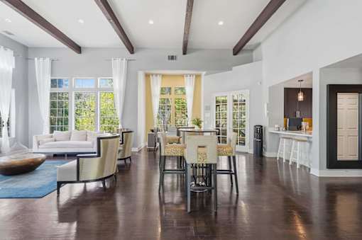 A spacious living room with a dining area and a kitchen in the background.
