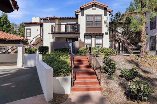A house with a red tiled roof and a staircase leading to the front door.