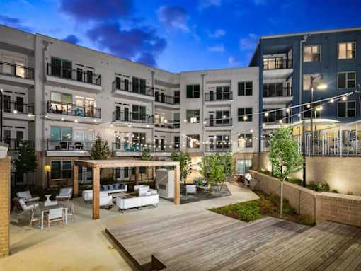 A modern apartment complex with a central courtyard and wooden deck.