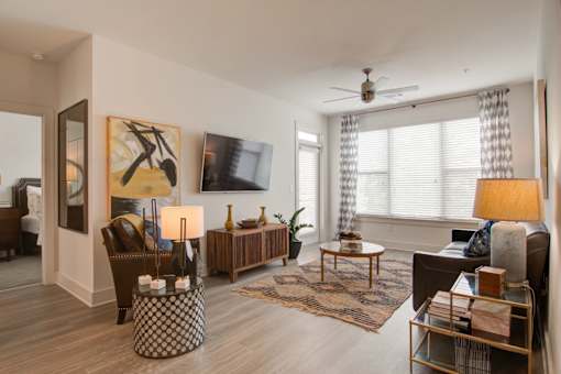 A living room with a brown couch, a coffee table, and a painting on the wall.