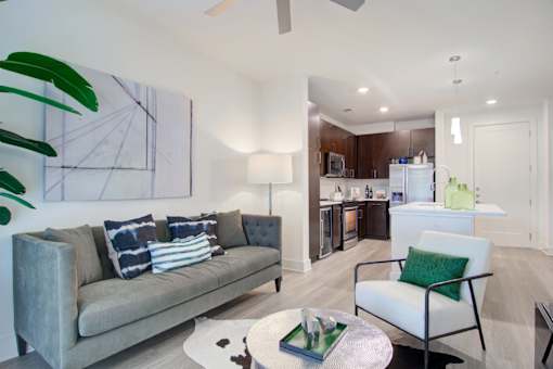 A living room with a grey couch and a green chair.