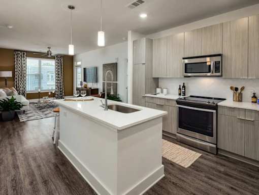 A modern kitchen with a white island and stainless steel appliances.