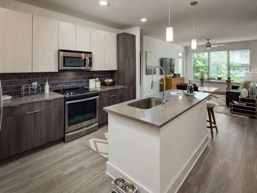 A modern kitchen with a white island and dark wood cabinets.