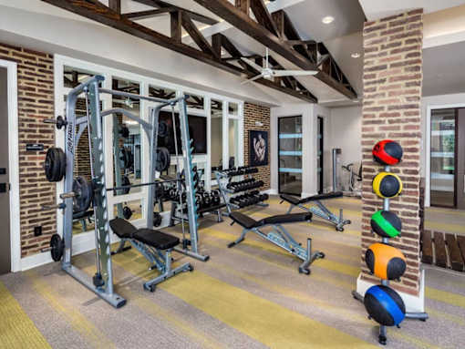 A home gym with a variety of equipment including a squat rack, bench, and weights.