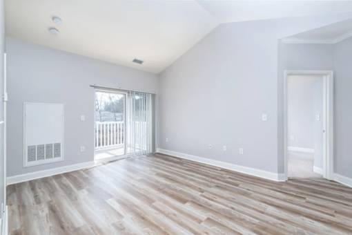 A room with wooden flooring and white walls.