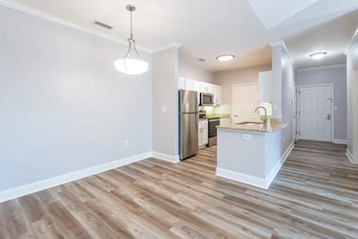 A kitchen with a refrigerator, sink, and cabinets.
