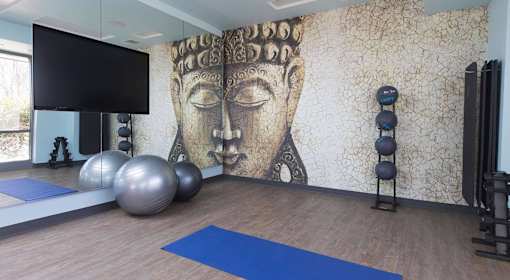 A yoga studio with a large Buddha mural on the wall.