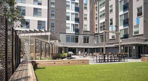 A modern building with a grassy area in front.