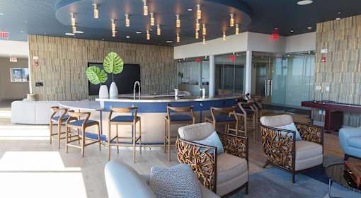 A modern lounge area with wooden chairs and a TV.