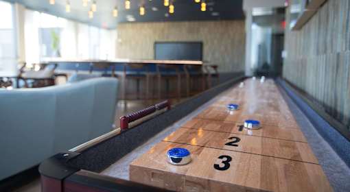 A bowling alley with a wooden lane and blue pins.