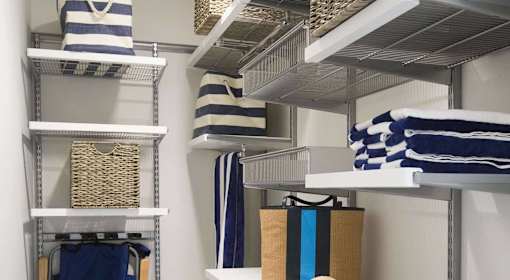 A white shelf with blue and white striped towels hanging on it.