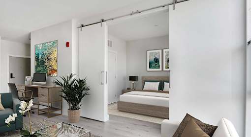 A modern bedroom with a bed, desk, and chair.