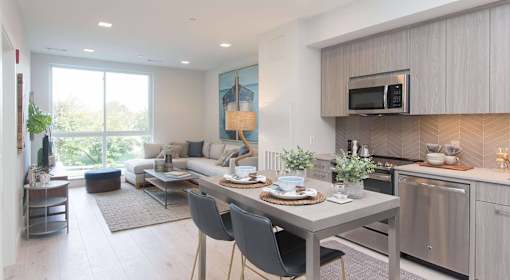 A modern kitchen with a dining table set for two.