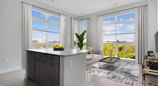 A modern kitchen with a large island and a view of the city.