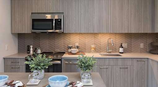A kitchen with a microwave above the stove and a sink with a faucet.