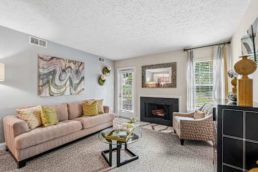 A living room with a fireplace and a painting on the wall.