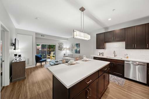 A modern kitchen with dark wood cabinets and a white countertop.