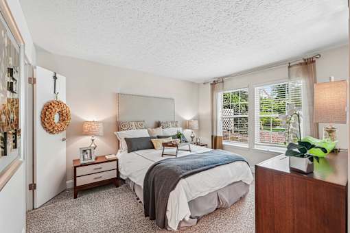 A bedroom with two beds and a nightstand with a clock.