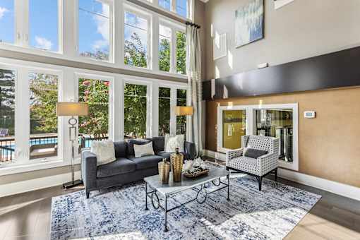 a living room with a couch and a coffee table and large windows