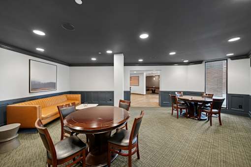 A conference room with a large table surrounded by chairs.