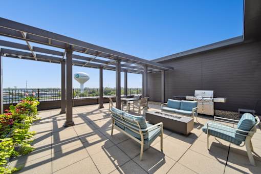 A patio with a table and chairs is covered by a roof.