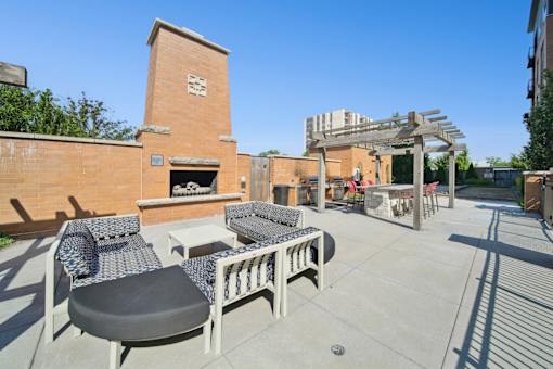 A patio with a fireplace and chairs.