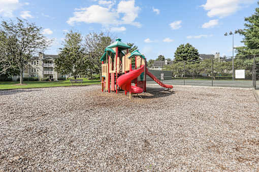 a playground with a red slide at a park