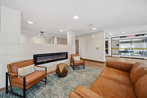 A living room with a fireplace and leather furniture.