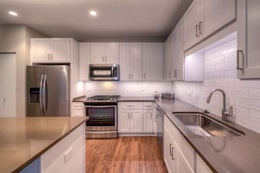 A modern kitchen with stainless steel appliances and white cabinets.