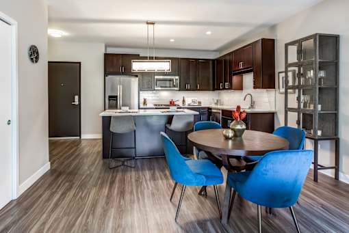 A modern kitchen with a dining table and chairs.
