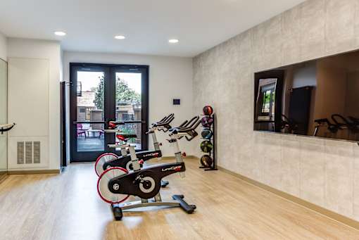 A room with a stationary bike and a treadmill.