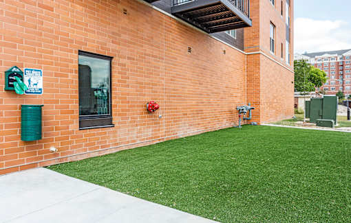 A red brick building with a green lawn in front.