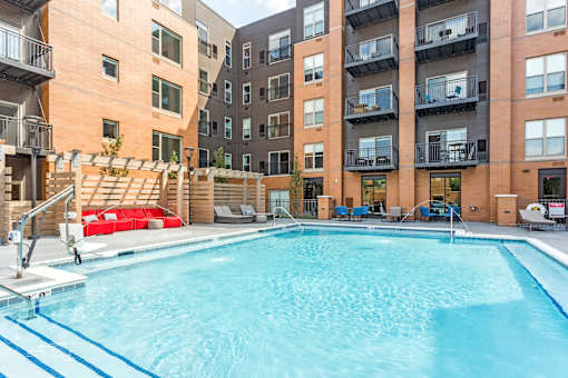 A large swimming pool in front of apartment buildings.