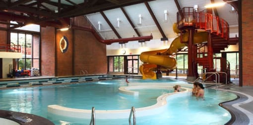 Mountain Park OR Apartments - MiLO at Mountain Park - Indoor Resort-Style Pool with Lap Swim Lanes, Recreational Swim Area, A Waterslide and a lot of Windows.