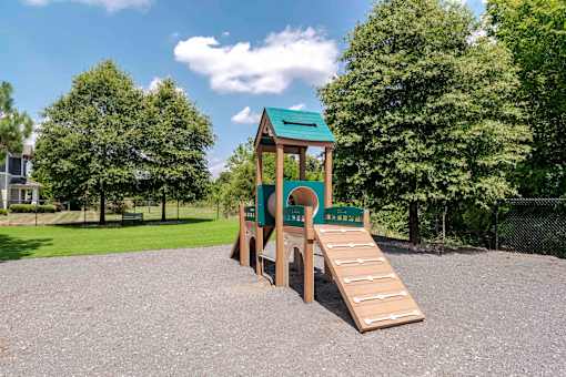 A playground with a green roof and a slide.