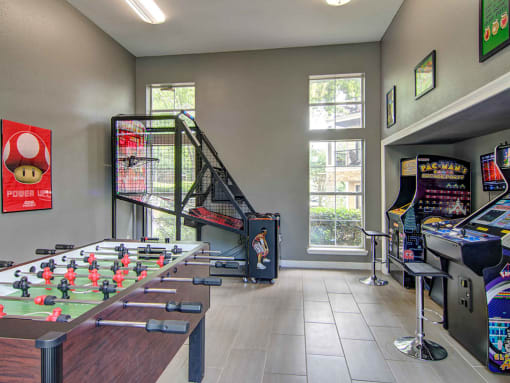 Alpharetta Apartments – The Ascent at Windward – Game room arcade with foosball table and other arcade games