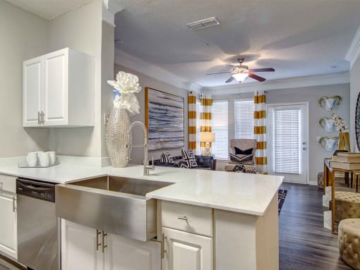 Pet-Friendly Apartments in Alpharetta, GA – The Ascent at Windward – view of living room from the kitchen with hardwood floors, ceiling fan and lots of light