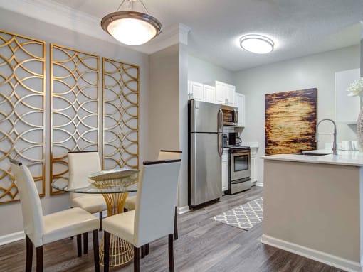 Alpharetta Apartments – The Ascent at Windward – dining room area with hardwood floors and view of kitchen