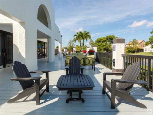 Pet-Friendly Apartments in Coconut Creek, FL – Waterview at Coconut Creek – sundeck with seating and palm trees in background