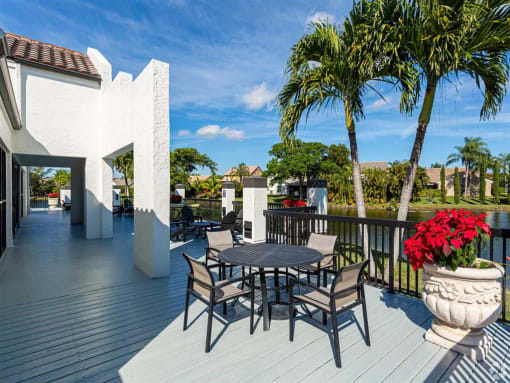 Apartments In Coconut Creek for Rent – Waterview at Coconut Creek – sundeck with table and chairs and palm trees in background