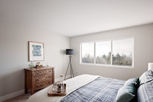Mountain Park Apartments - MiLO at Mountain Park - Spacious Bedroom with Large Window, a Bed, Double Nightstands, and Carpet.