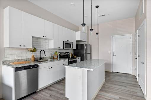 A modern kitchen with white cabinets and a central island.