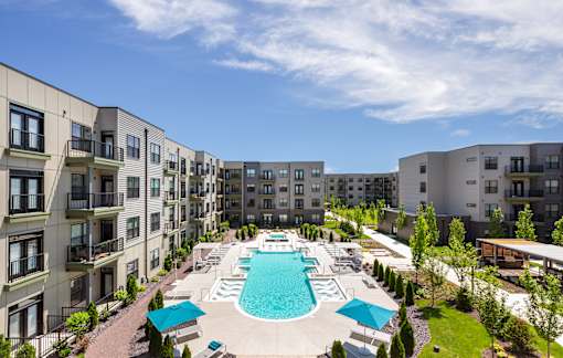 A large swimming pool surrounded by apartment buildings.