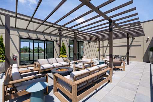 A wooden patio with a fire pit and seating area.